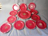 a lot of red plates with gold designs on them