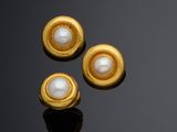 two pairs of gold and pearl earrings on a black surface