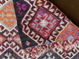 a close up of a colorful rug on a brown surface