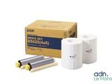 two rolls of white paper sitting next to a box of yellow rolls