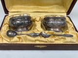 two silver spoons and a bowl in a box