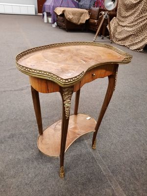 une petite table surmontée d'une étagère, placée au milieu d'une pièce