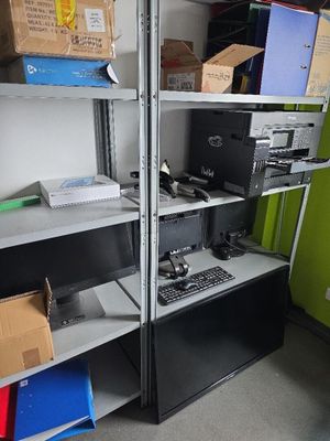 une pièce remplie de cartons, avec un ordinateur posé sur une étagère
