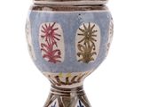 a blue and white vase with red flowers on it