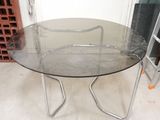 une table en verre avec un piètement en métal dans une pièce
