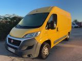 une camionnette jaune garée sur un parking près de buissons