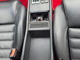 the interior of a car with black leather seats and a red carpet