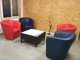 trois chaises et une table dans une pièce où est accrochée une horloge au mur