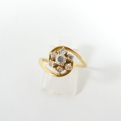 gros plan d'une bague en or avec des diamants sur une surface blanche