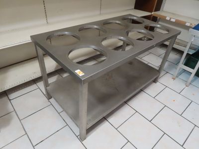 une table en acier inoxydable sur laquelle sont posés quatre plats