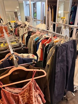 beaucoup de vêtements suspendus à une étagère dans un magasin