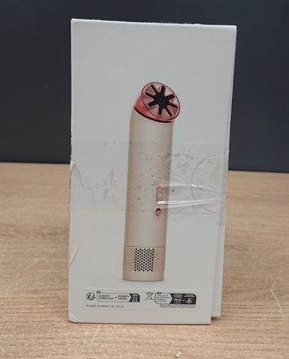 boîte contenant un appareil électronique posée sur une table en bois, sur fond noir