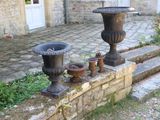 deux vases posés sur un mur de pierre, à côté d'un mur de briques