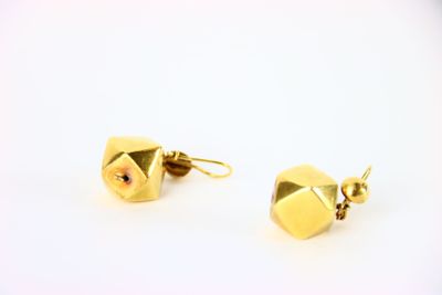 une paire de boucles d'oreilles en or sur fond blanc