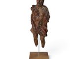 an image of a wooden sculpture of a man on a stand