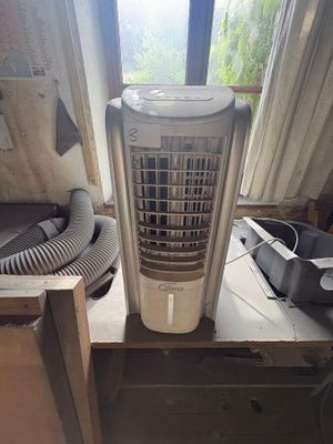 un petit climatiseur posé sur une table près d'une fenêtre