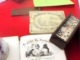 un plateau rouge sur lequel se trouvent un livre, des dés et d'autres objets