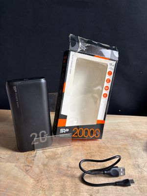 une boîte contenant une batterie externe posée sur une table à côté d'un chargeur