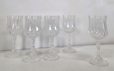quatre verres à vin sont alignés sur une surface blanche