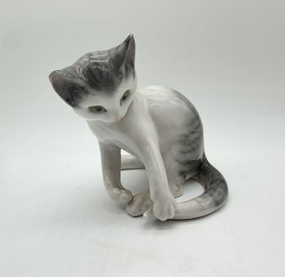 a figurine of a cat sitting on a white surface
