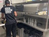 un homme qui se tient debout dans la cuisine en train de préparer à manger