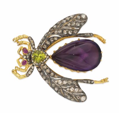 un gros plan sur une broche en forme de libellule ornée d'une fleur violette
