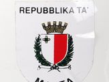a sticker on the back of a white car with a red and white emblem