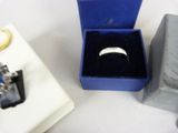 a ring in a blue box next to other jewelry items
