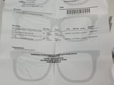 someone is holding a pair of glasses on top of a piece of paper