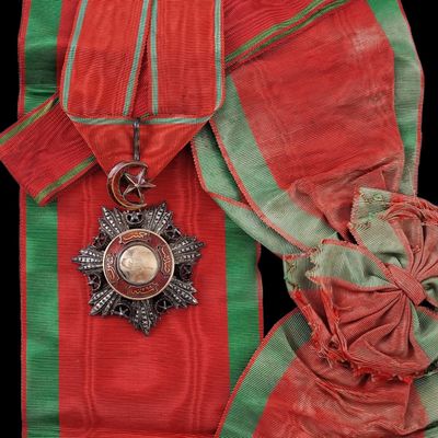 une image représentant un ruban rouge et vert surmonté d'une médaille