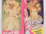 Des boîtes contenant chacune deux poupées Barbie en tenue de mariée sont présentées sur une surface blanche