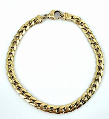 gros plan d'un bracelet en chaîne en or sur fond blanc