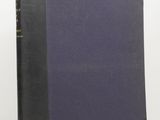 a black book with a blue cover sitting on top of a white table