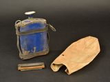a small blue bottle and a wooden object on a black surface