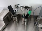 a lot of utensils in a cup on the kitchen counter