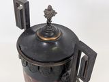 a black and red container with a metal lid