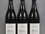 three bottles of red wine sitting on top of a table
