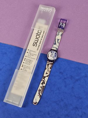 a watch sitting next to a tube of toothpaste on a blue and pink surface