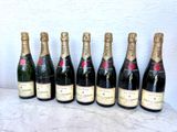 six bouteilles de champagne alignées sur une table