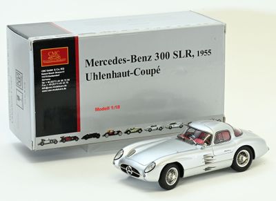 une maquette argentée de voiture devant une boîte