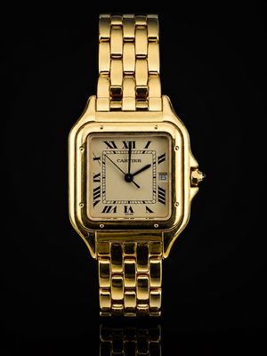 une image d'une montre en or avec des chiffres romains sur le cadran