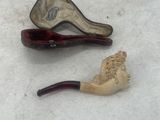 two different types of smoking pipes on the ground