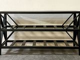 a black metal shelf with three shelves on it