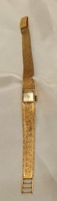 une montre en or posée sur un drap blanc