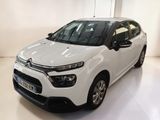 La voiture blanche est garée dans une pièce blanche au sol blanc.