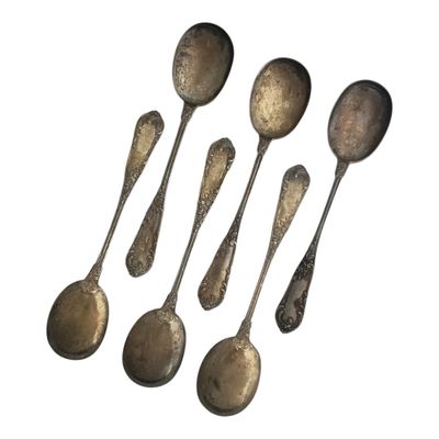 six silver spoons are lined up on a white surface