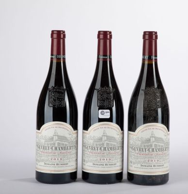 trois bouteilles de vin sont alignées sur une surface blanche