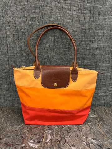 LONGCHAMP – Sac en toile orange tricolore pliable.