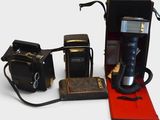 two old cameras and an old camera next to each other