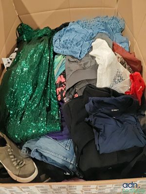 une boîte en carton remplie de vêtements et une paire de baskets